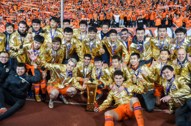 12月19日，山东鲁能泰山队成员在颁奖仪式后与奖杯合影。